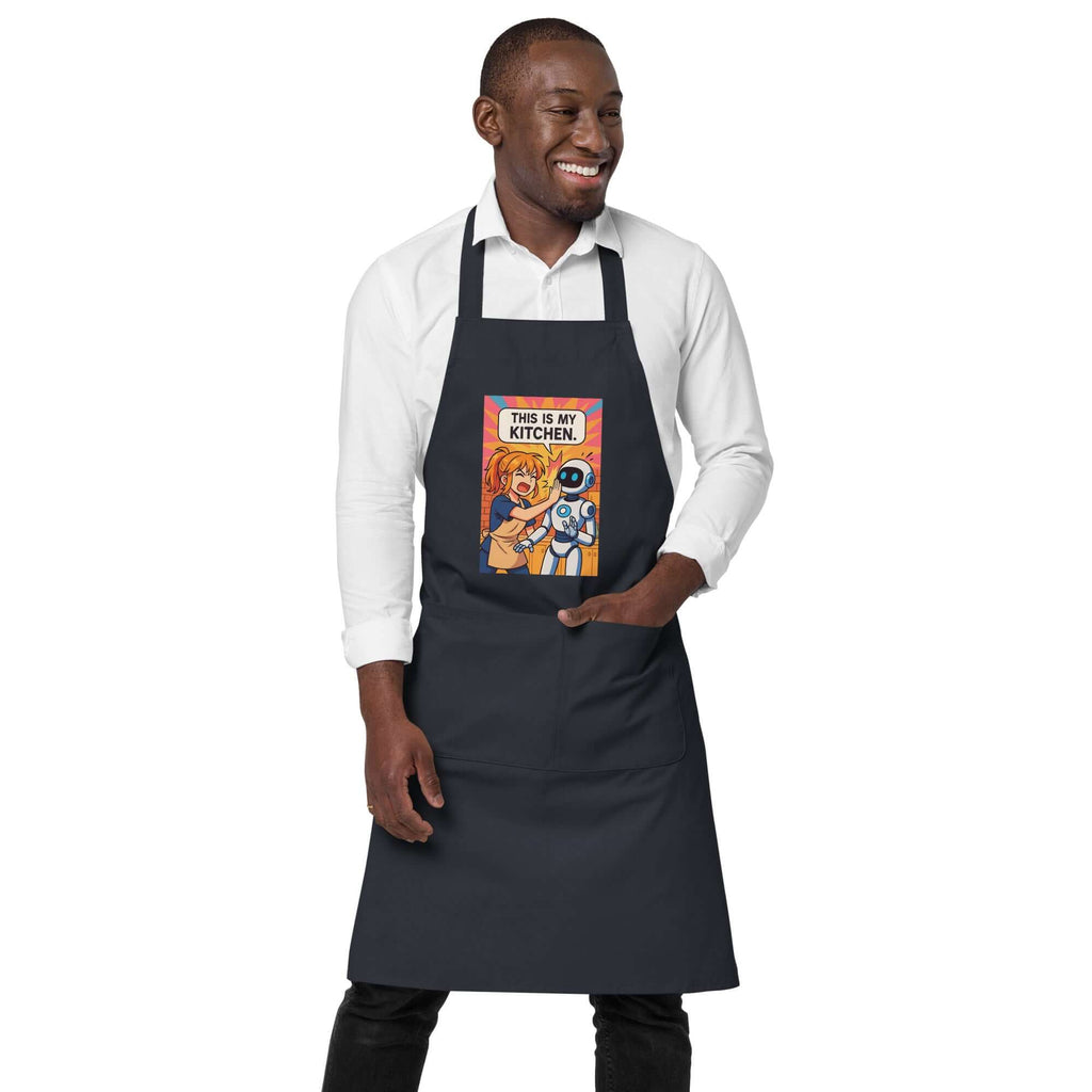 Man smiling in an organic cotton apron featuring anime characters with the text 'This is my kitchen'.